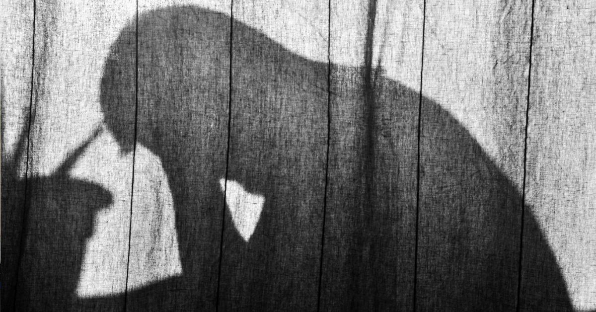 Shadow of a person praying fervently.